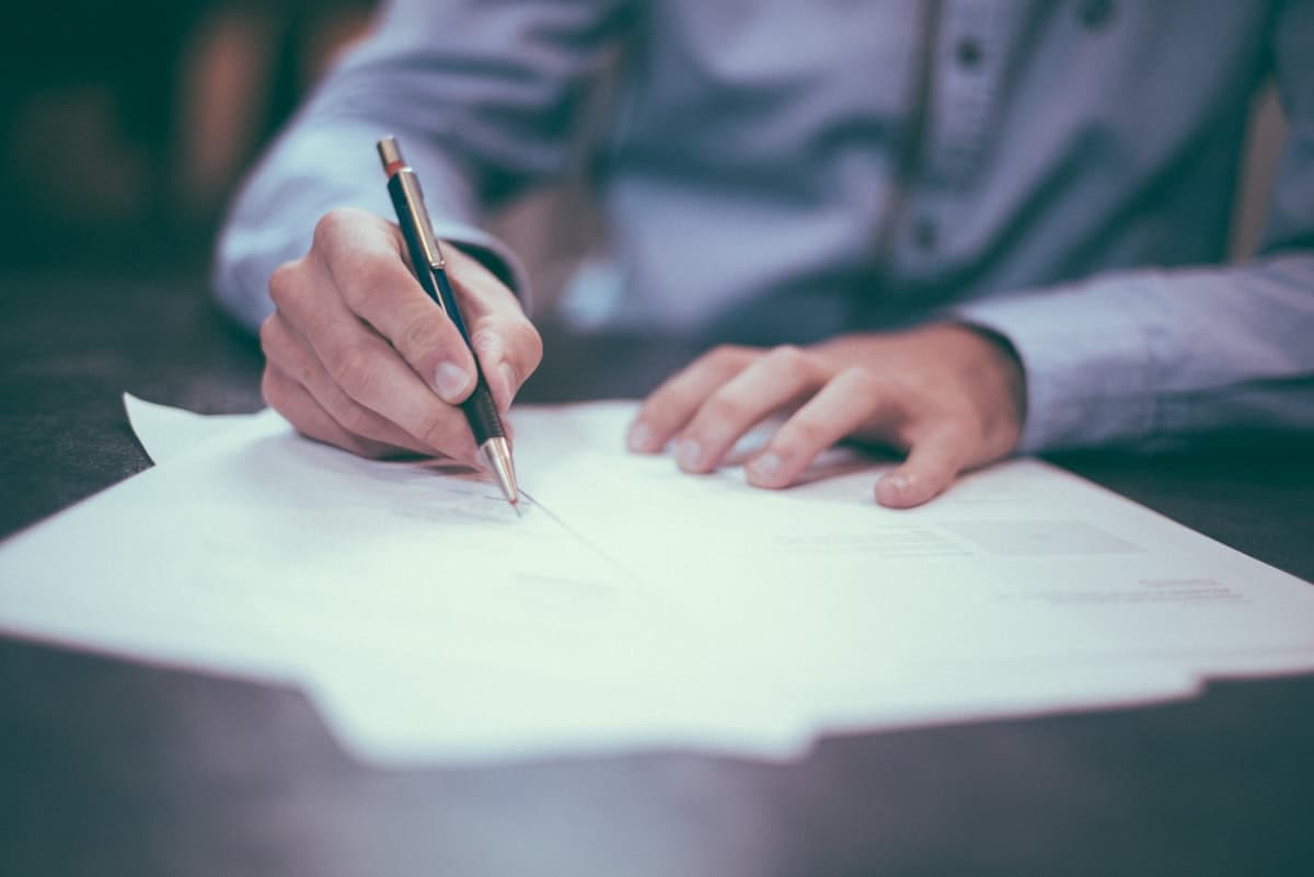 Professional signing paperwork at a desk